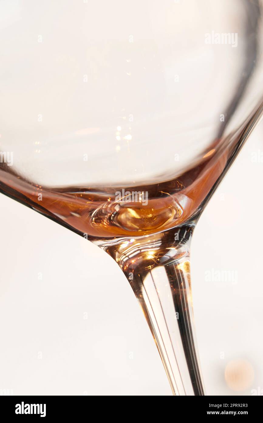 Closeup of the last sip of white wine against a light background 