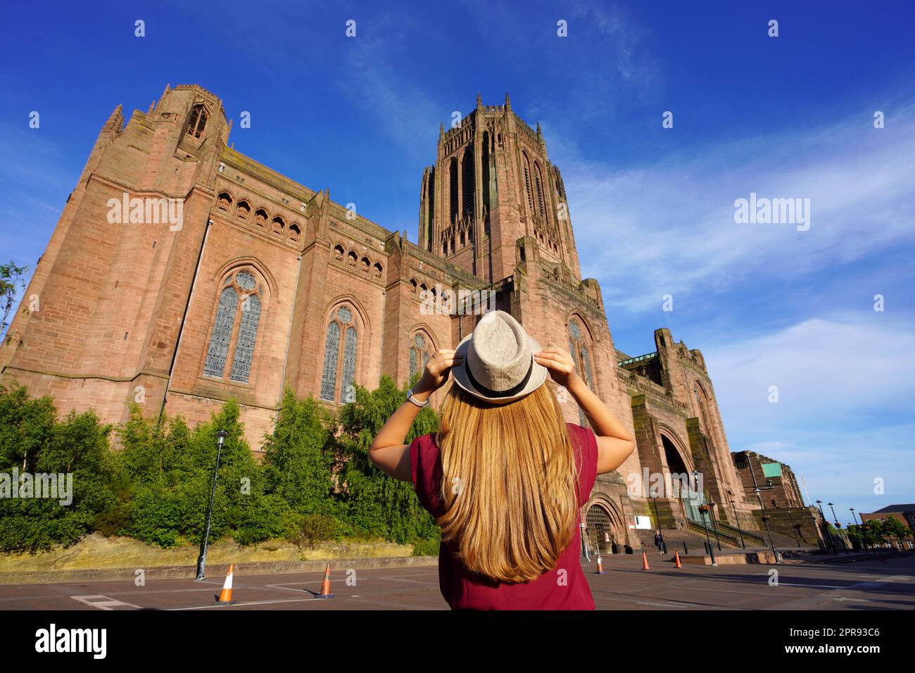Back view of tourist girl looking the Cathedral Church of Christ against blue sky in Liverpool on sunset, United Kingdom Stock Photo
