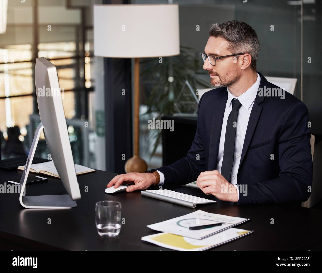 Delivering excellent work is what opens new doors. a businessman using his computer while sitting at his desk. Stock Photo