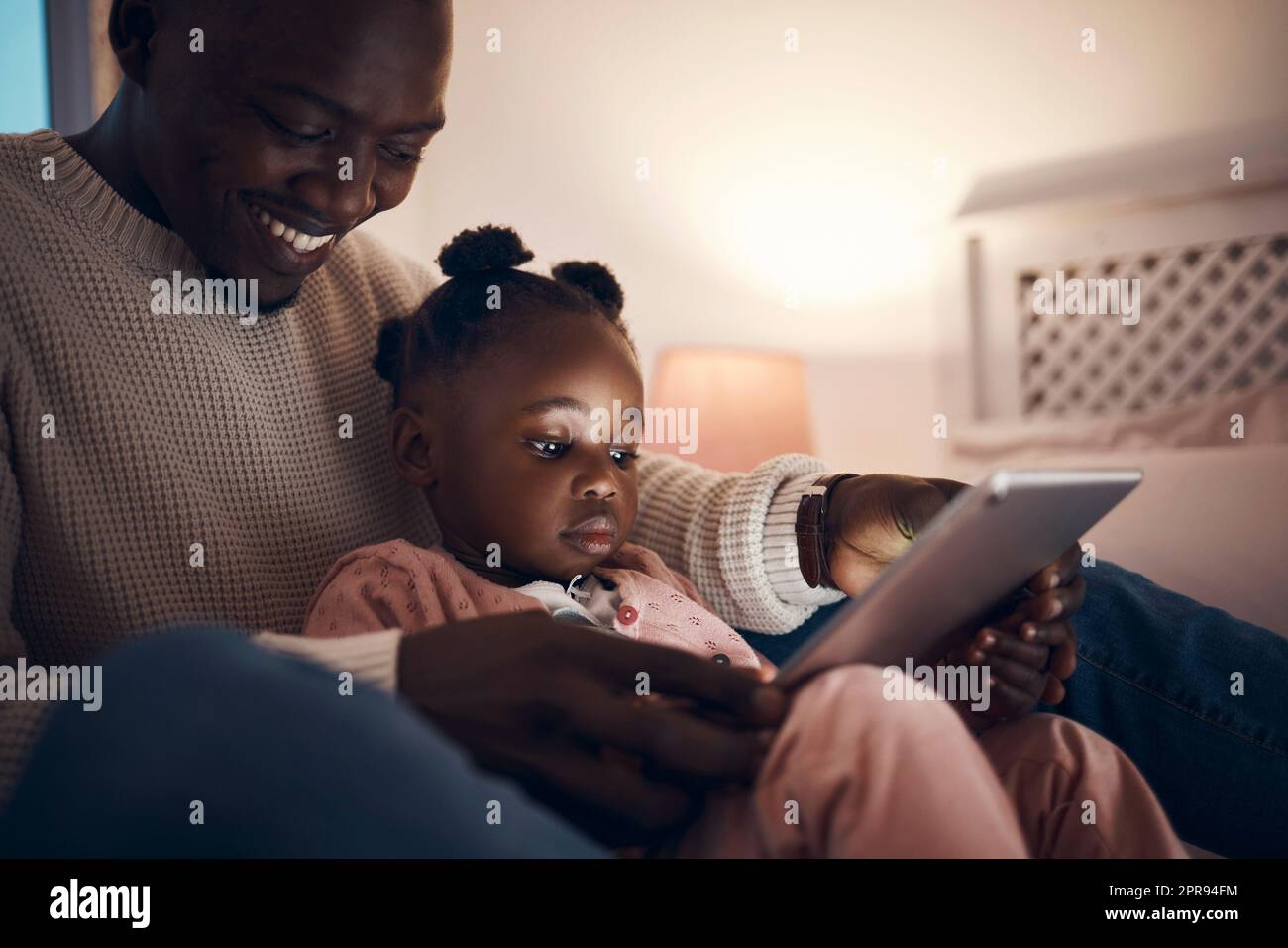 Do you want to read a fairy story. a father reading his daughter bedtime stories. Stock Photo