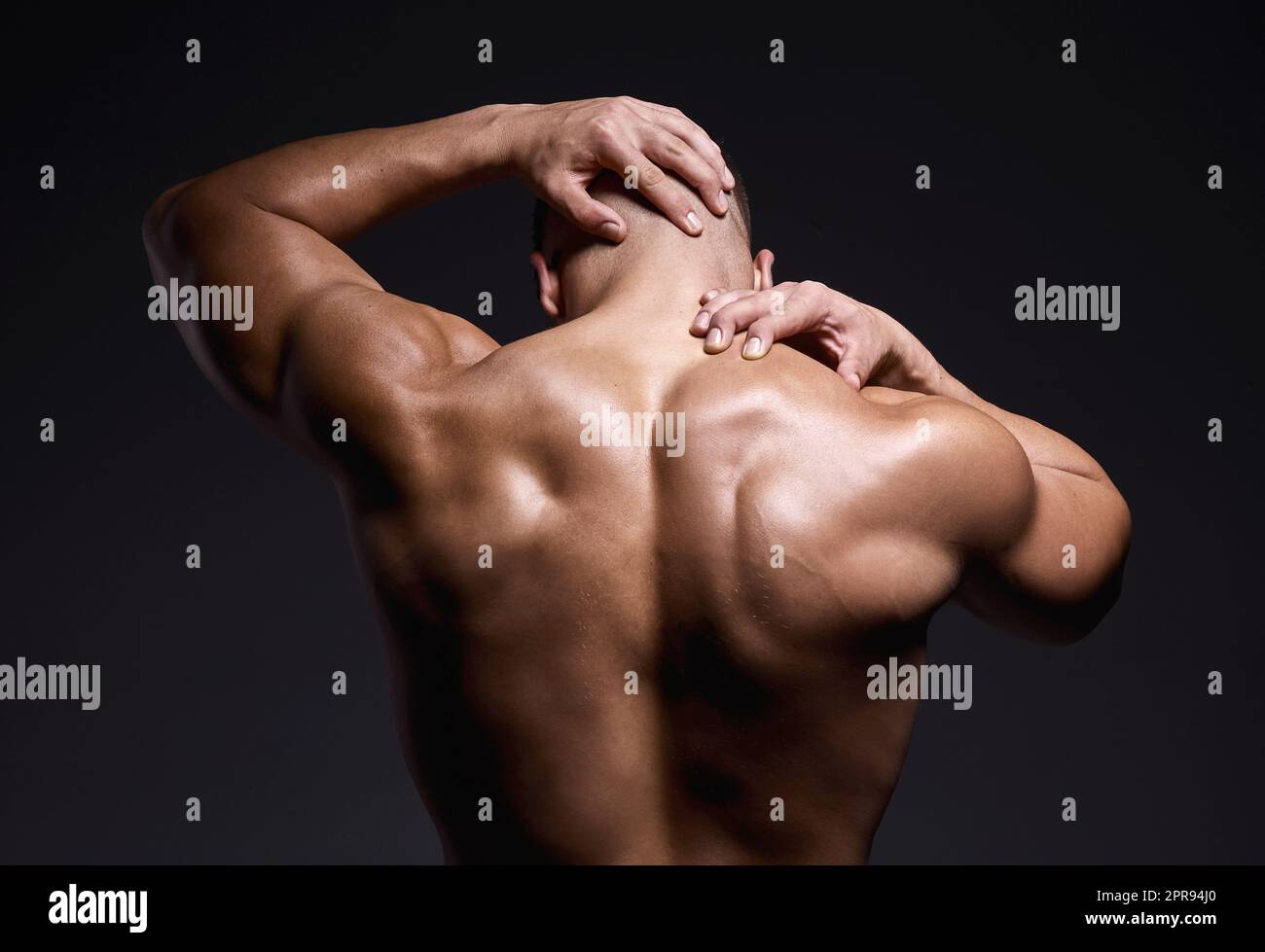Id never turn my back on a workout. a muscular young man posing against a black background. Stock Photo