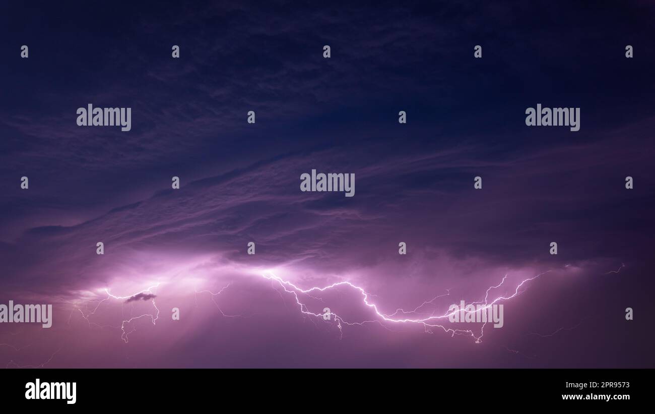 Bright Lightning On Purple Night Sky During Hunderstorm Stock Photo