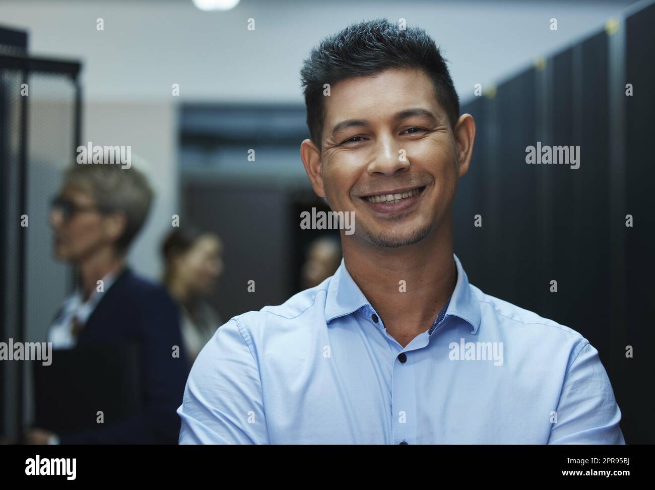 Another version of a beautiful mind. Portrait of a happy man working in a server room. Stock Photo