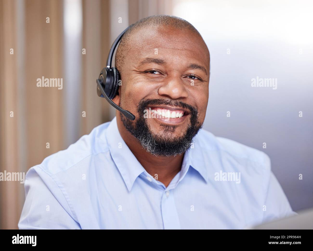 A smile can do wonders for your day. a young male call center agent at work. Stock Photo
