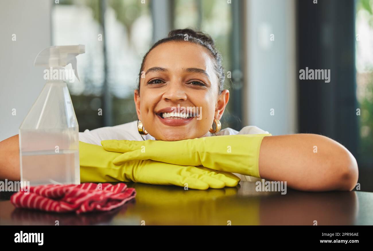 I love having a clean home. a young woman about to clean a wood table ...
