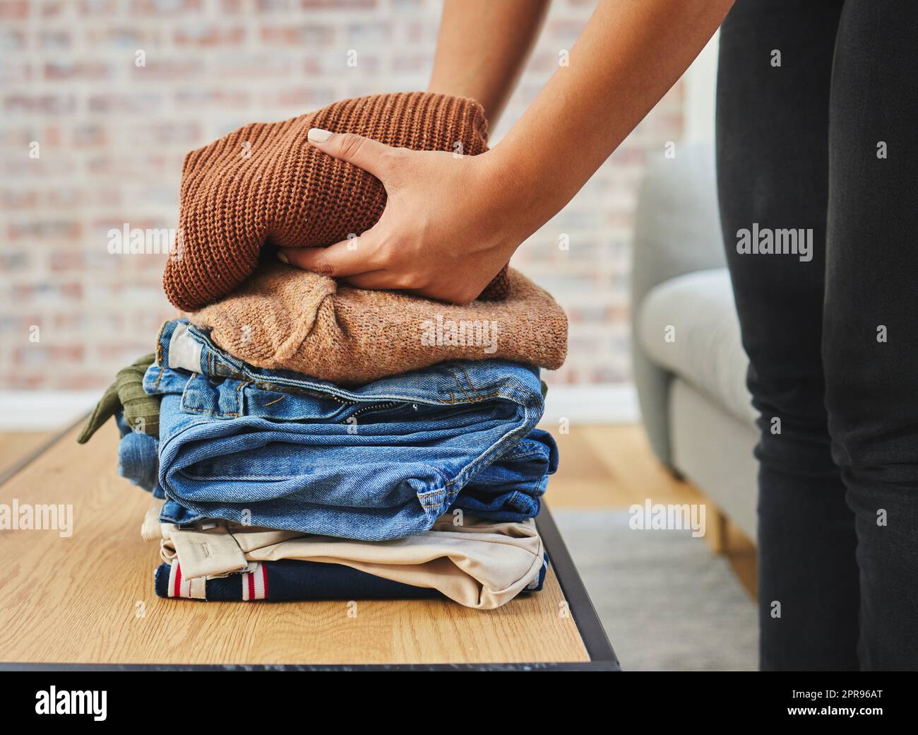 Keeping my closet clean and neat. a woman folding a load of laundry. Stock Photo