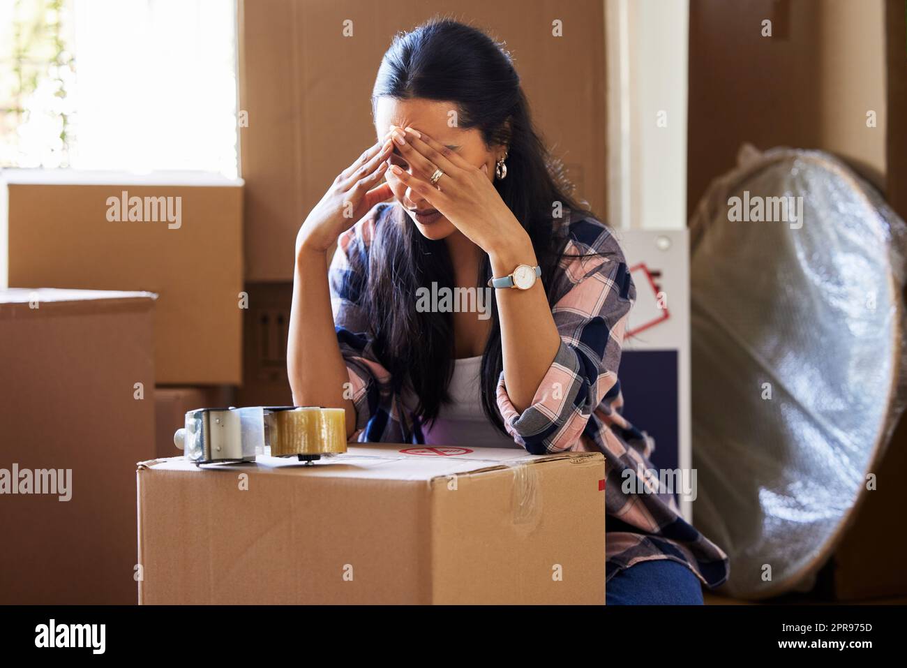 Everyone has their own reason for moving. a young woman packing up to