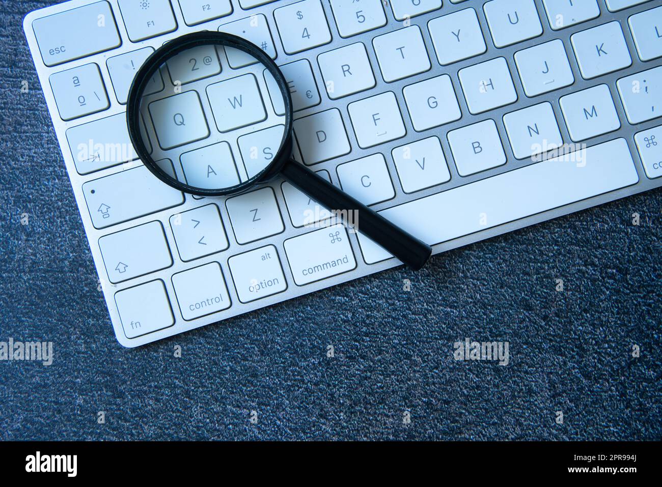 Magnifying glass and laptop keyboard. Seo, data search in the network ...