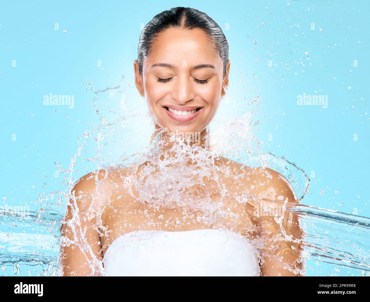 Always practice good hygiene. Studio shot of clean water splashing against a woman. Stock Photo