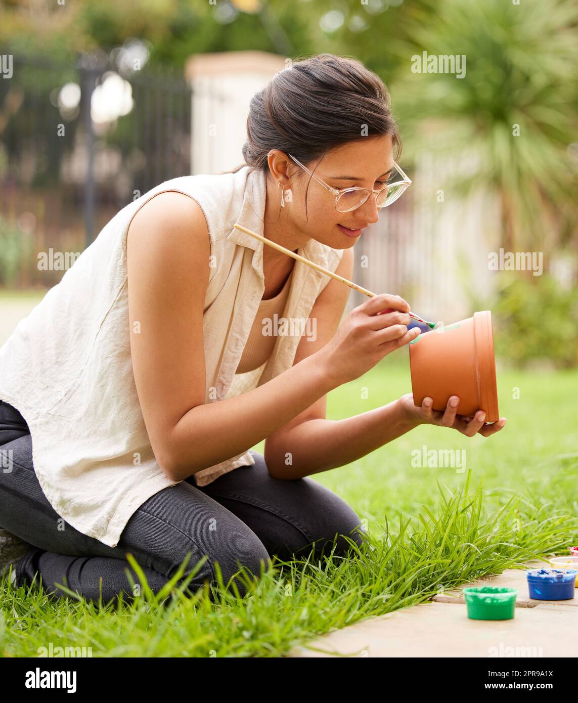 Creativity doesnt wait for that perfect moment. s young woman painting a pot in the garden at home. Stock Photo