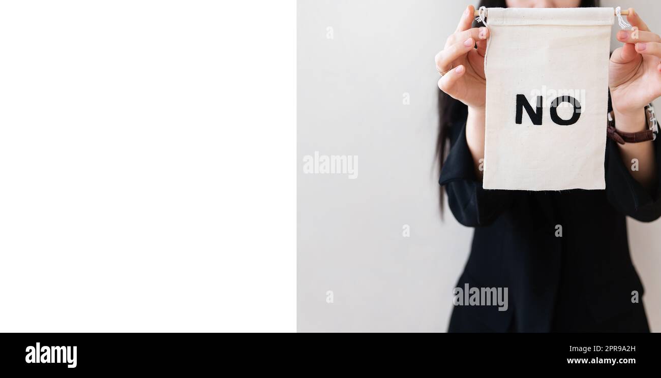 Young business woman in a black suit shows a blank white billboard on a white isolated background. There is no inscription on the poster. Concept for business and advertising. Lots of space for writing. Banner. Stock Photo