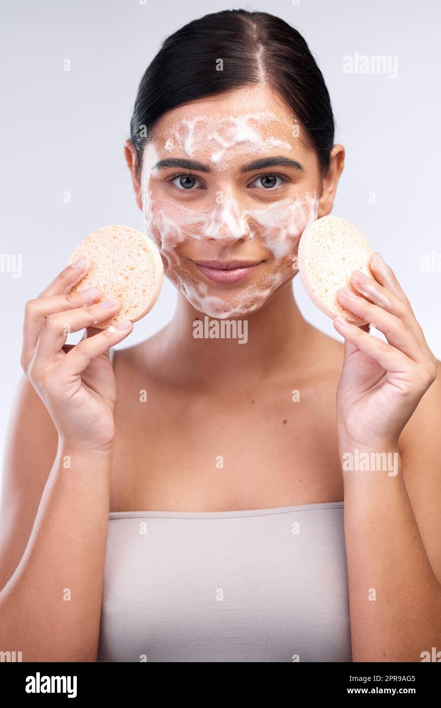 Remove dead skin for smoother skin and clearer pores. Studio shot of a beautiful young woman washing her face. Stock Photo