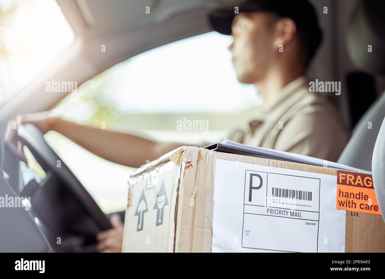 Keeping your packages safe. a delivery man driving to drop off a package. Stock Photo
