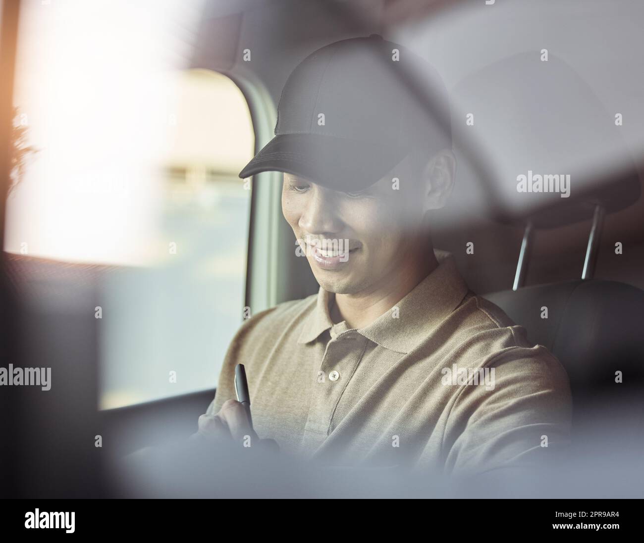 Bringing people joy daily. a delivery checking his deliveries before dropping them off. Stock Photo