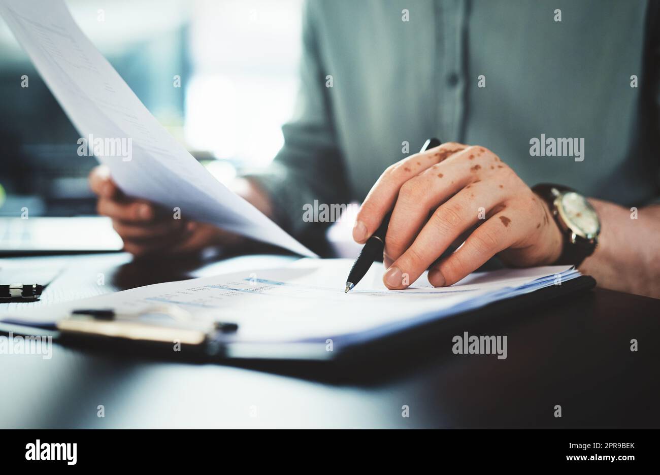 Sorting out some business. an unrecognizazble businessman doing paperwork in an office at work. Stock Photo