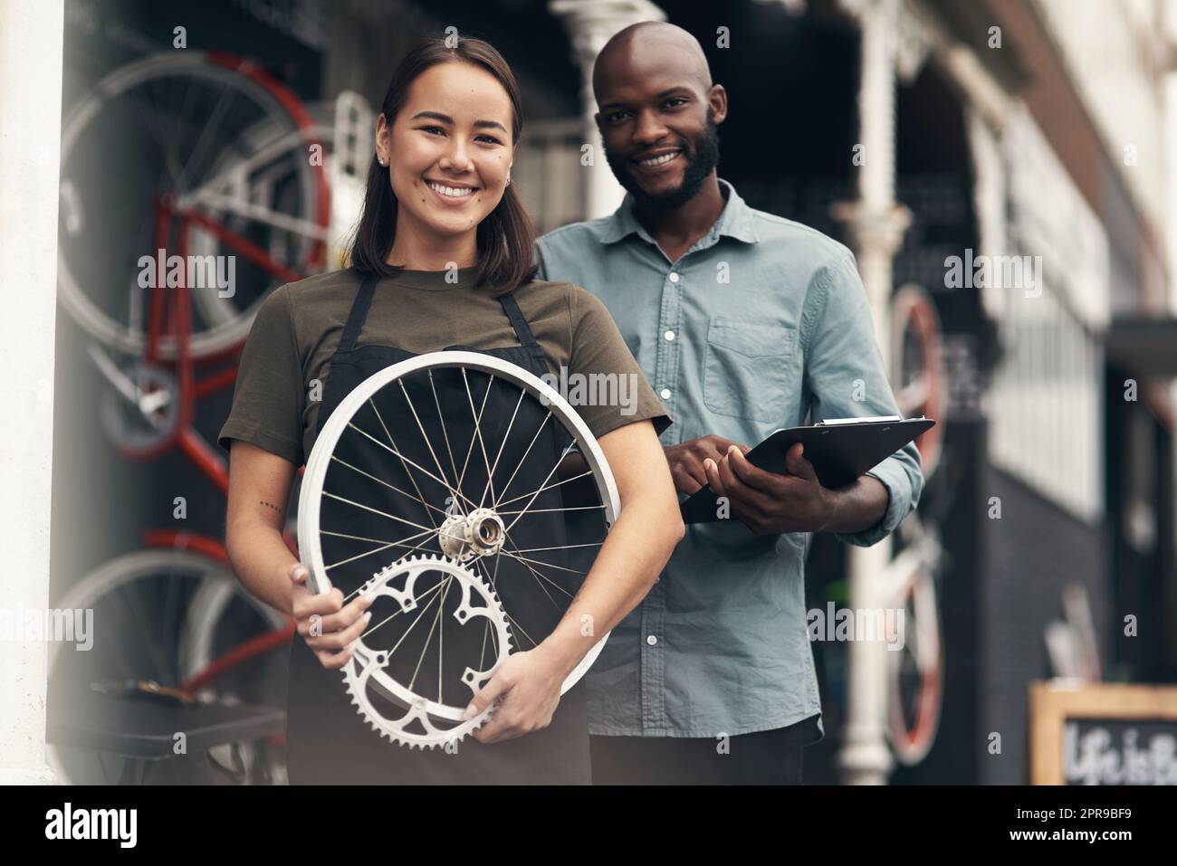 Weve got all the spare parts inside. two young business owners standing outside their bicycle shop during the day. Stock Photo