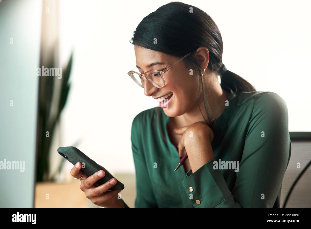 I love texts that make me smile. a young businesswoman using her smartphone to send text messages. Stock Photo