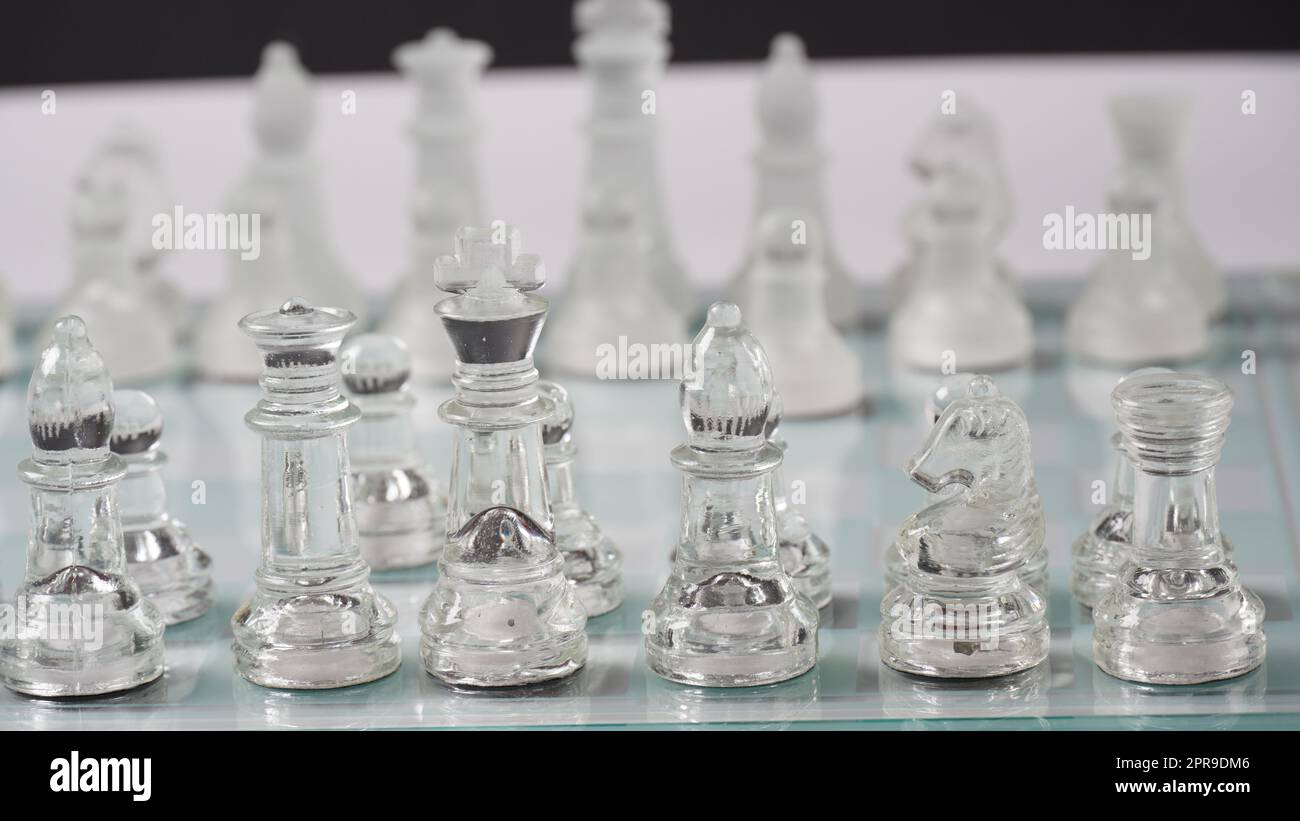 Transparent chess figures, on starting position, on reflective chess