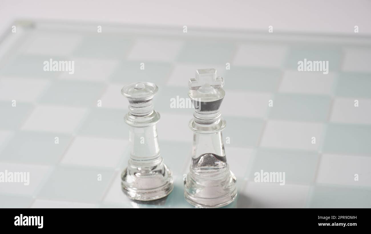 Pieces of transparent chess, king and queen. Transparent chess figures on chessboard. Stock Photo