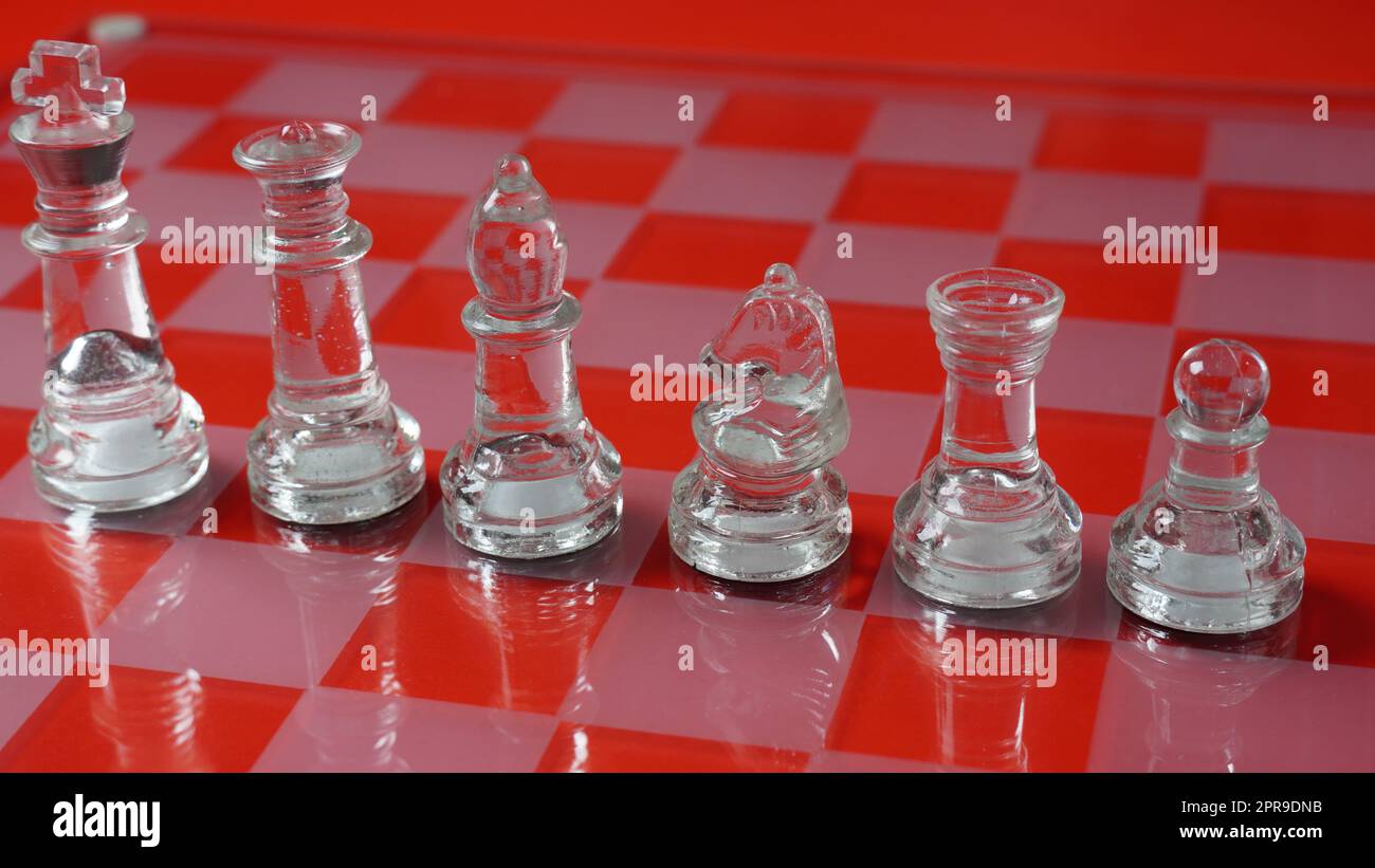Pieces of transparent chess, King,  Queen, Knight(Horse) , Bishop, Rook, Pawn . Transparent chess figures on chessboard, red tone Stock Photo