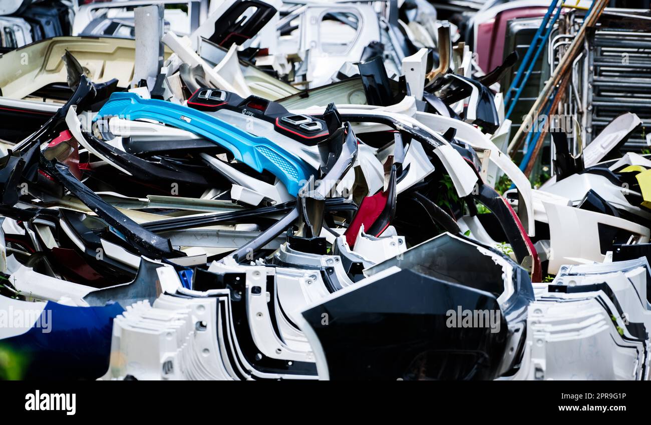 Pile of used front bumper, rear bumper, and spoiler of car for recycle. Carbon fiber, PU and PP plastic auto parts products. Automotive industry. Scrap yard of old bumper, spoiler. Plastic waste. Stock Photo