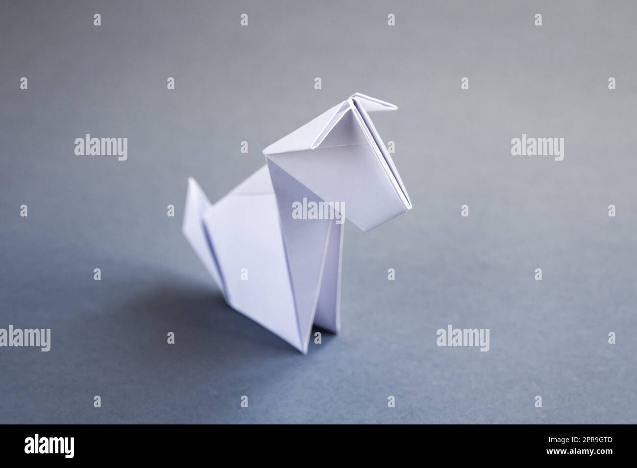 White paper dog origami isolated on a grey background Stock Photo