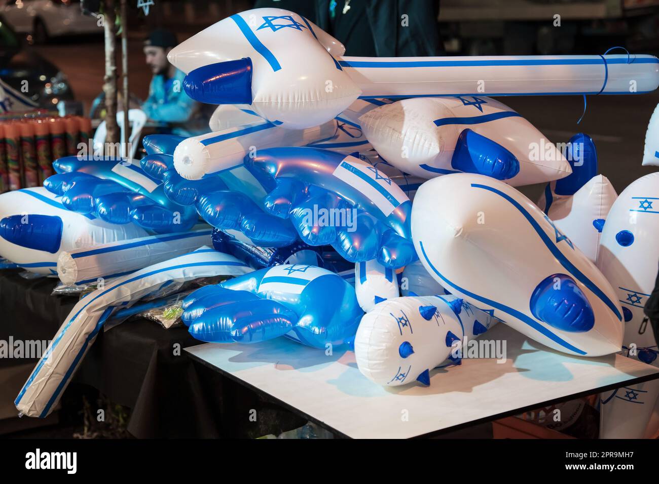 Rishon Lezion, Israel- 25 April, 2023.Toys as an inflatable hammers and a clubs with national symbols of Israel sold on the street at night Stock Photo