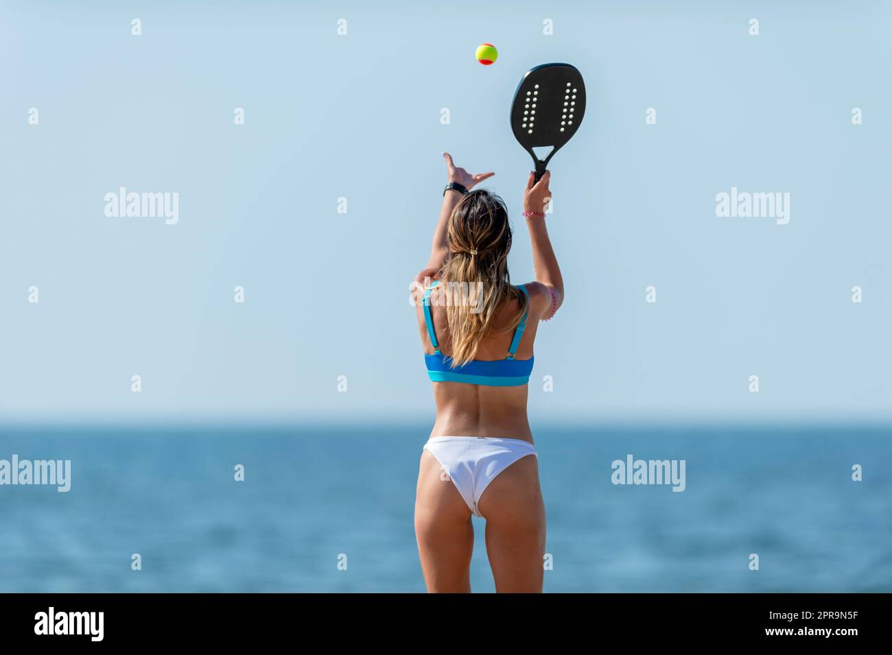 Woman playing beach tennis on a beach. Professional sport concept. Horizontal sport theme poster, greeting cards, headers, website and app Stock Photo