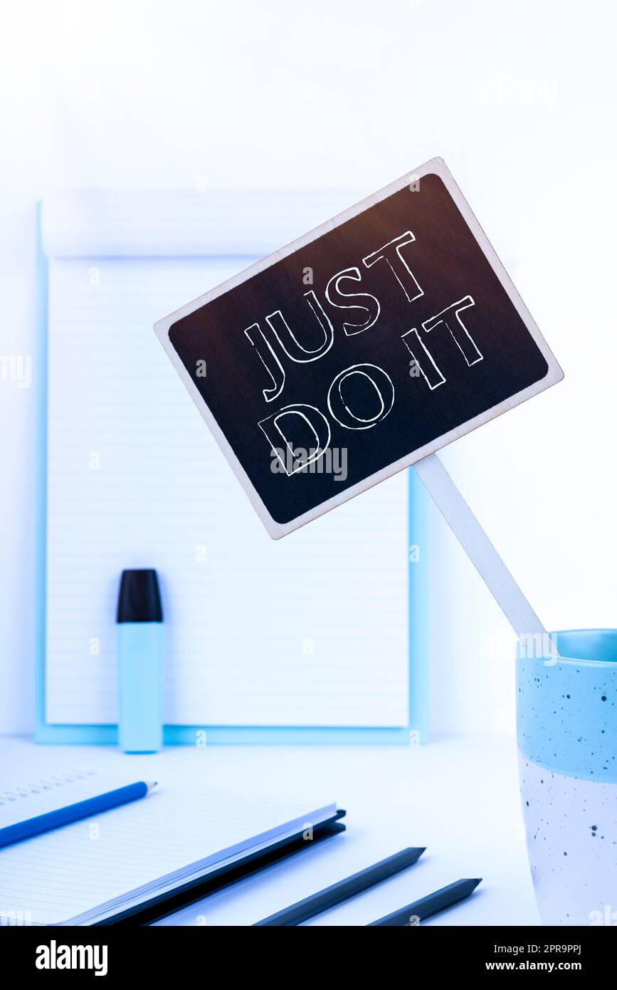 Conceptual display Just Do It. Business idea Motivation for starting doing something Have discipline Small Blackboard With Important Message In Cup On Desk With Clipboard. Stock Photo