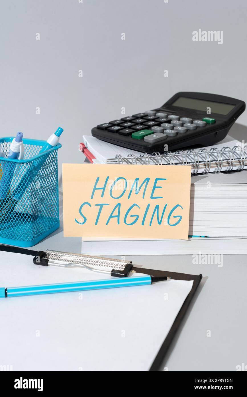 Sign displaying Home Staging. Conceptual photo Act of preparing a private residence for sale in the market Important Idea Shown On Phone On Desk With Cup With Pencils And Books. Stock Photo