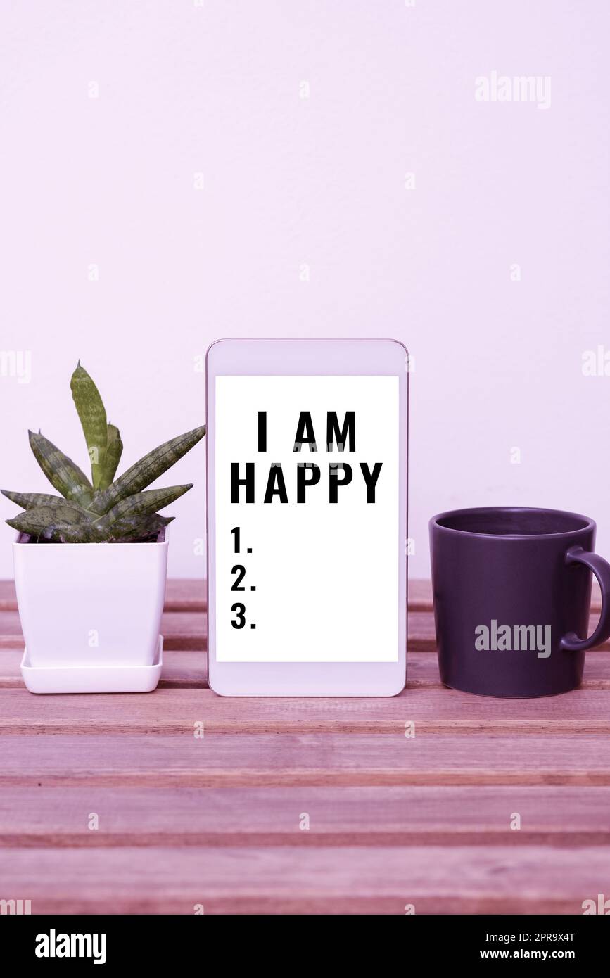 Text caption presenting I Am Happy. Concept meaning To have a fulfilled life full of love good job happiness Tablet With Important Information On Table With Plant And Cup Of Coffee. Stock Photo