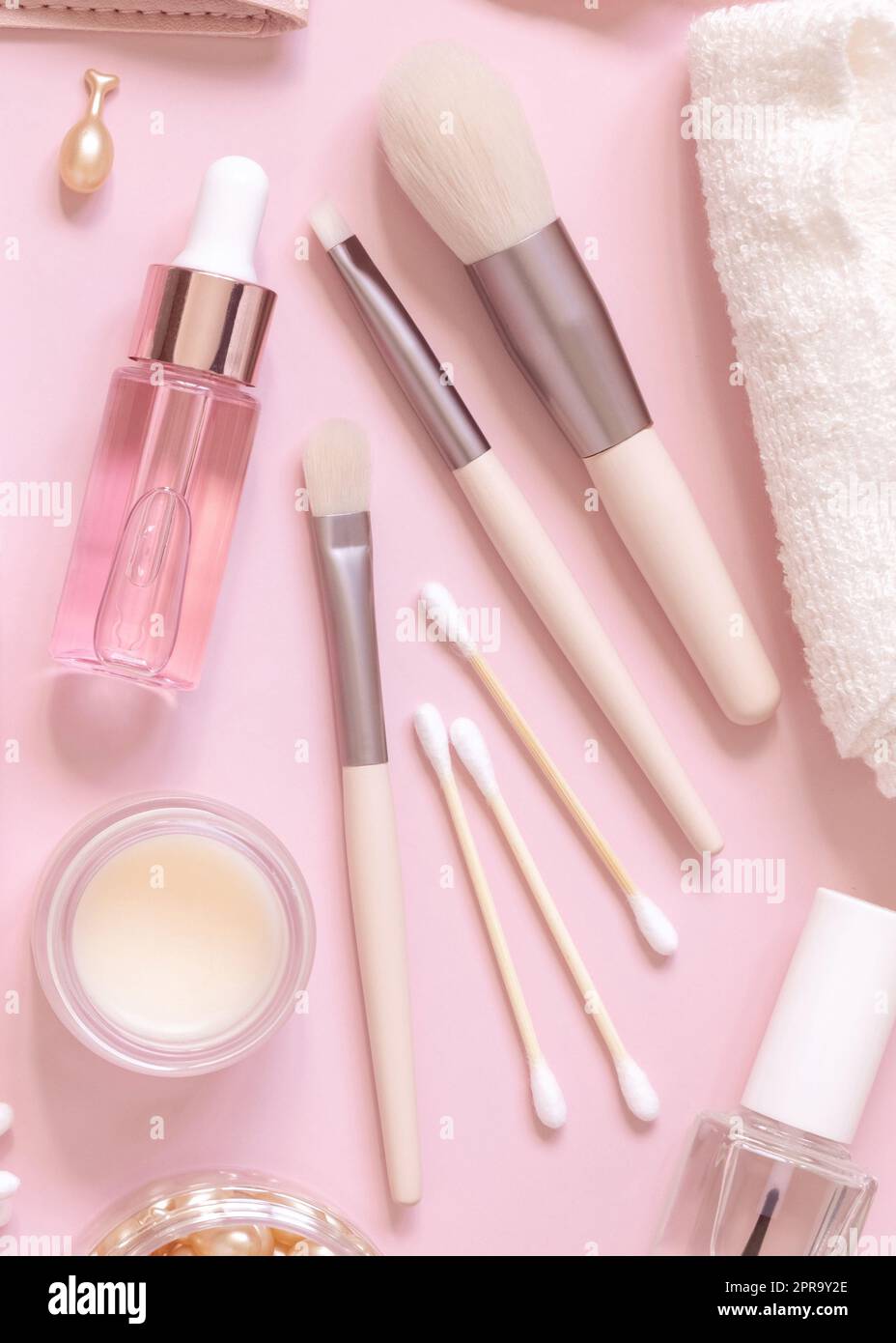 Skin care products and make up brushes on light pink, top view Stock Photo