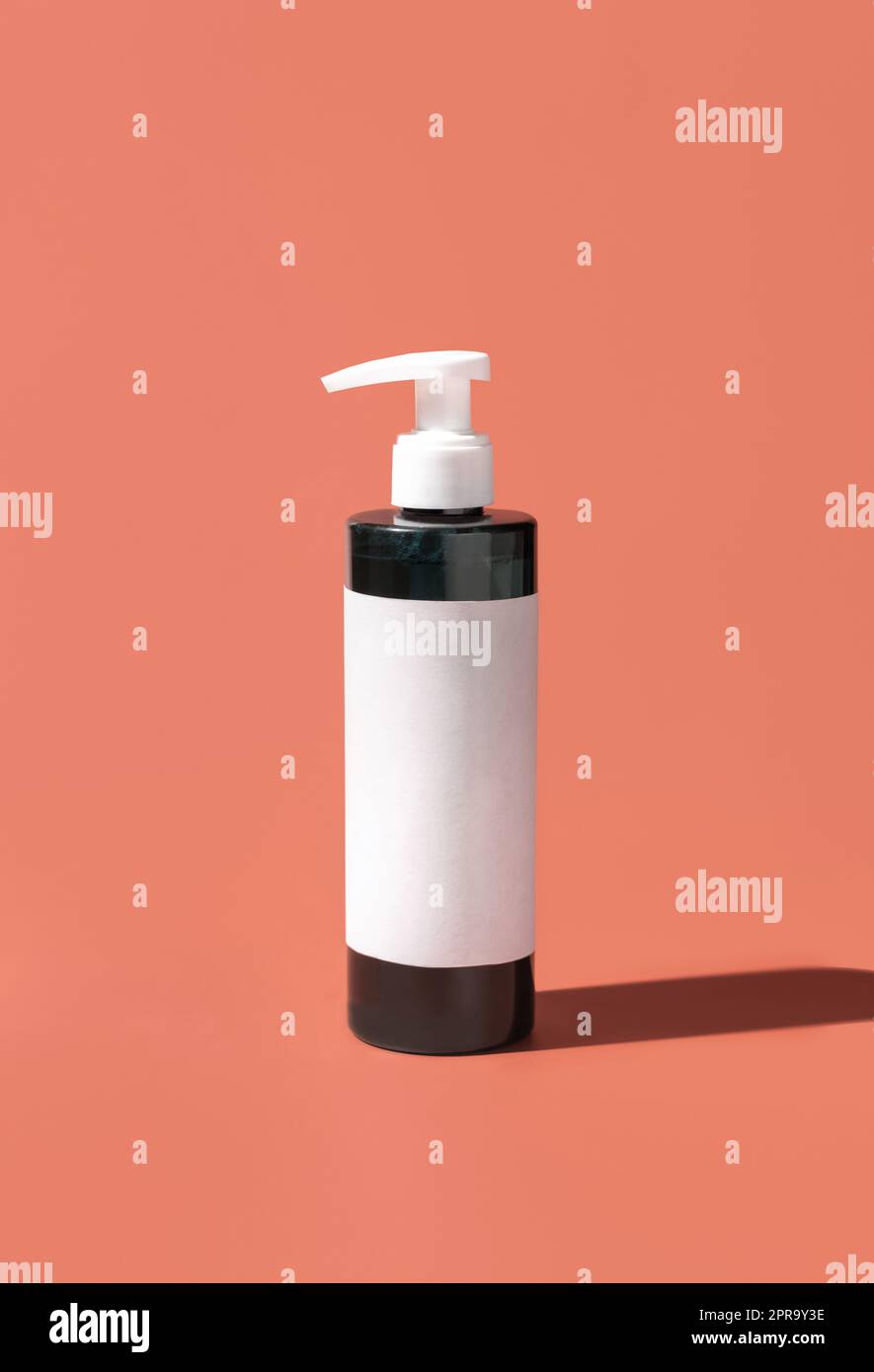 Cosmetic One pump Plastic bottle with blank label on pink, hard shadows. Mockup Stock Photo