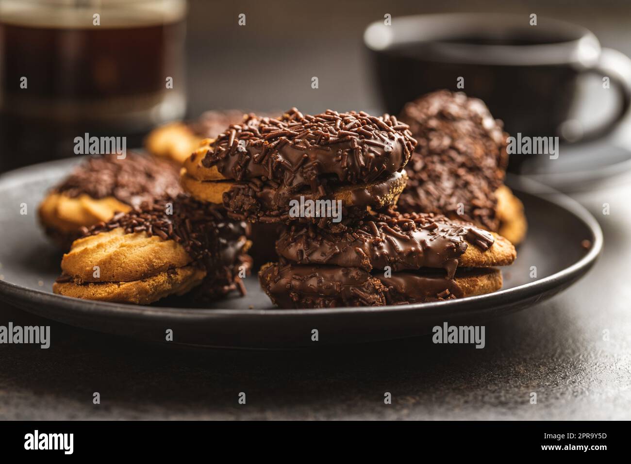 Petit fours with chocolate sprinkles. Mini chocolate dessert on plate. Stock Photo