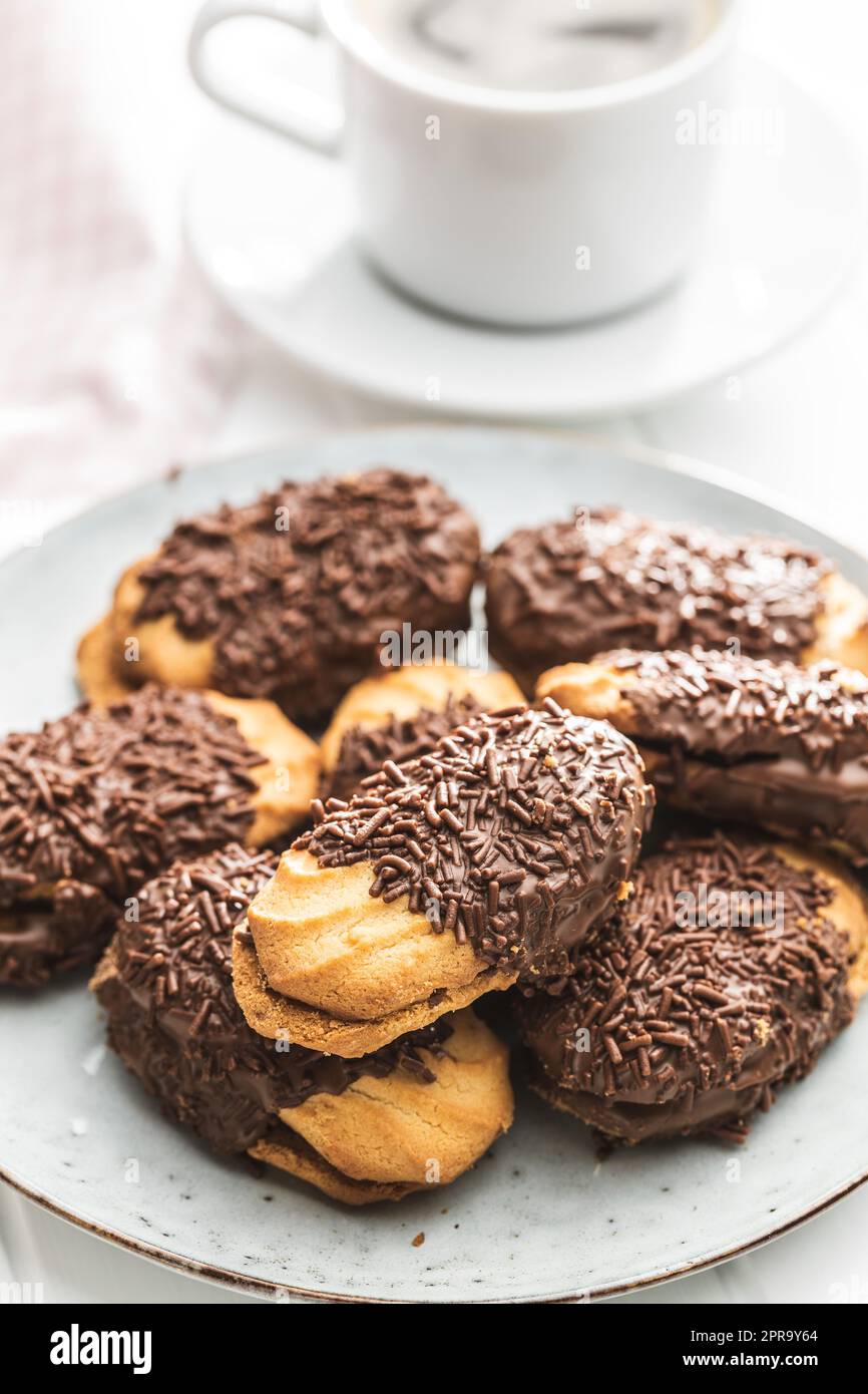 Petit fours with chocolate sprinkles. Mini chocolate dessert on plate. Stock Photo