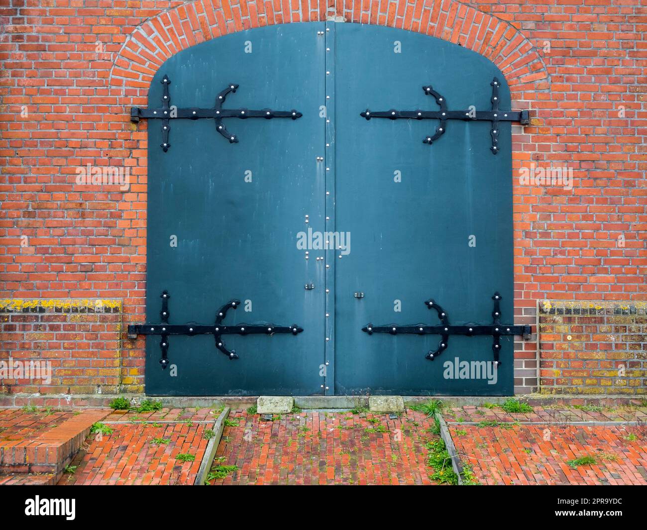 Metal door in a brick wall Stock Photo Alamy