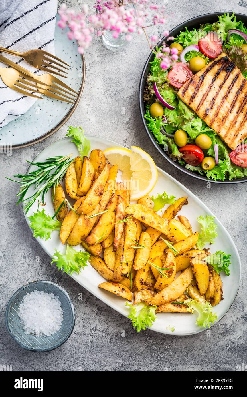 Potato wedges, oven roasted with mixed salad and grilled cheese Stock Photo