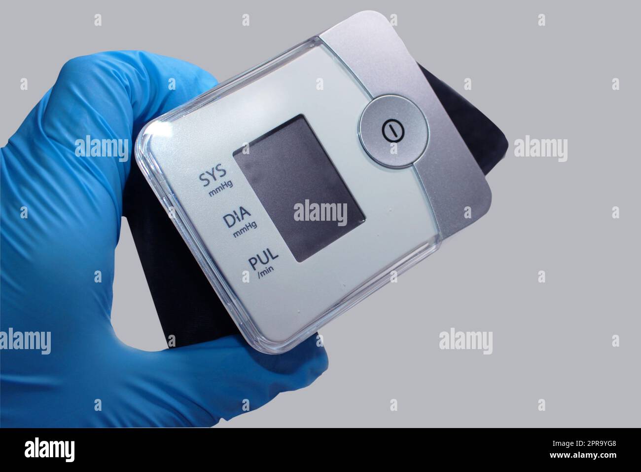 The doctor's hand in a blue medical glove holds a tonometer. Medicine concept Stock Photo