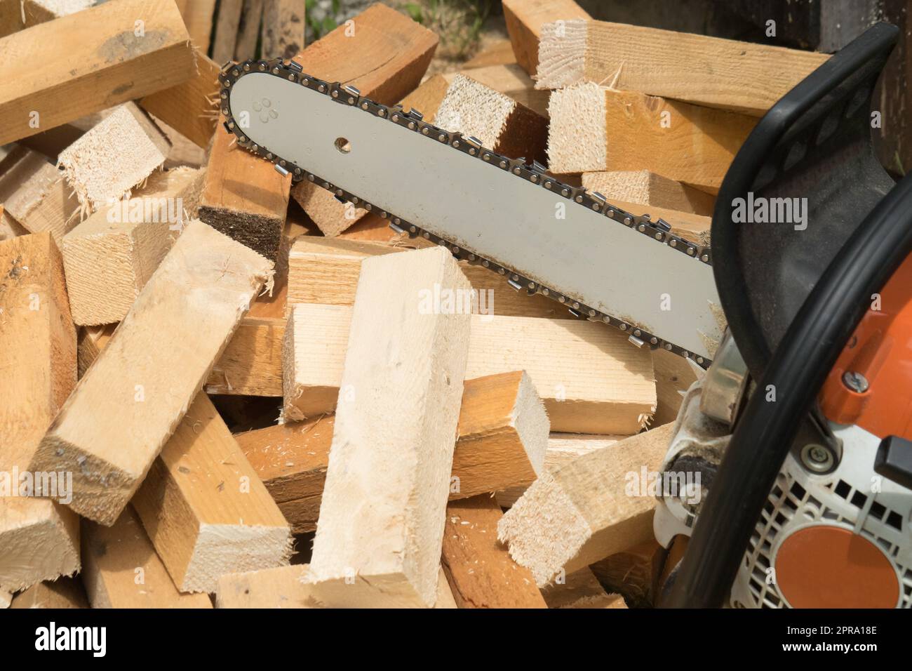Constructor worker cutting planks with chainsaw Stock Photo