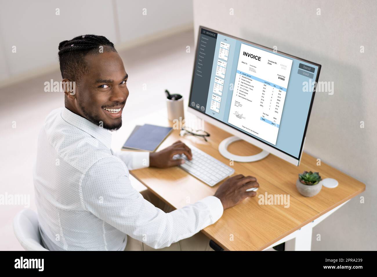 Businessperson Working On Computer With Invoice On Computer Stock Photo