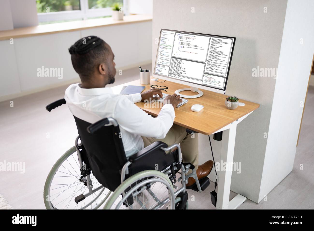 African American Coder Using Computer At Desk Stock Photo