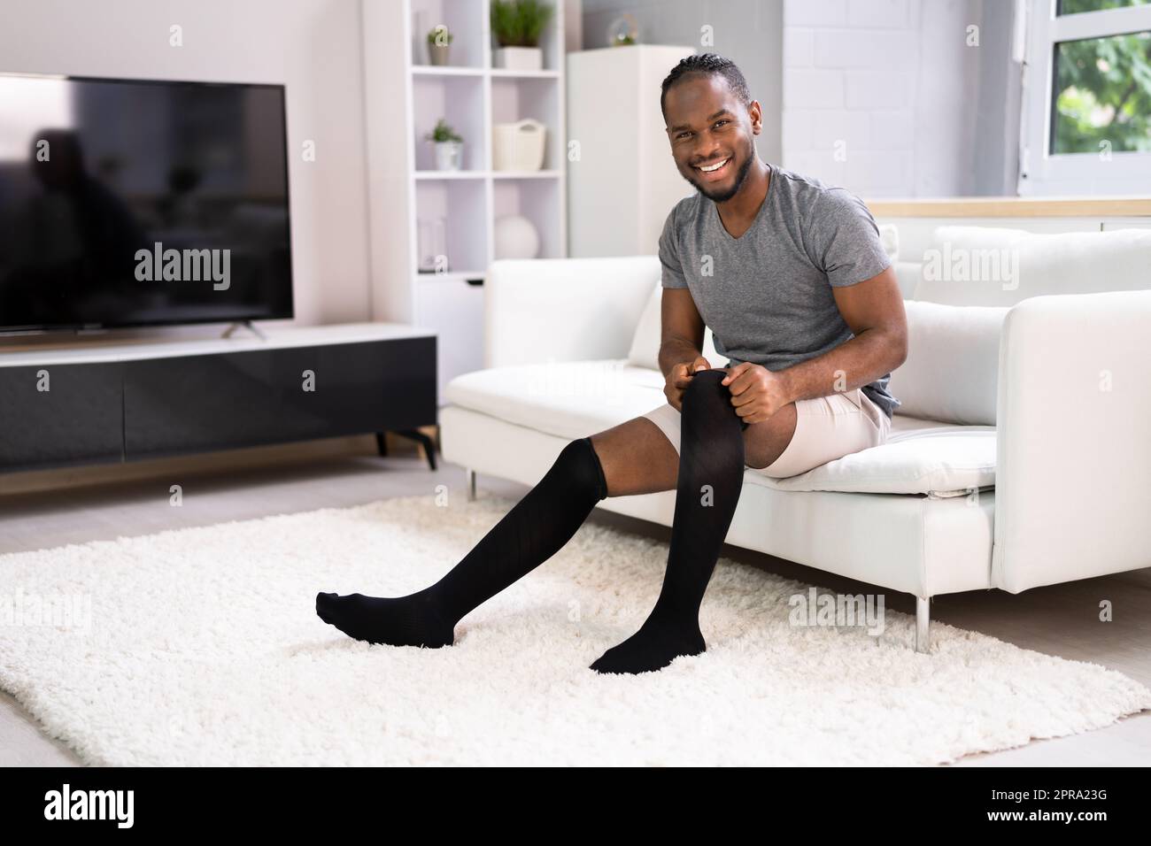 Man Putting On Medical Compression Stockings Stock Photo Alamy