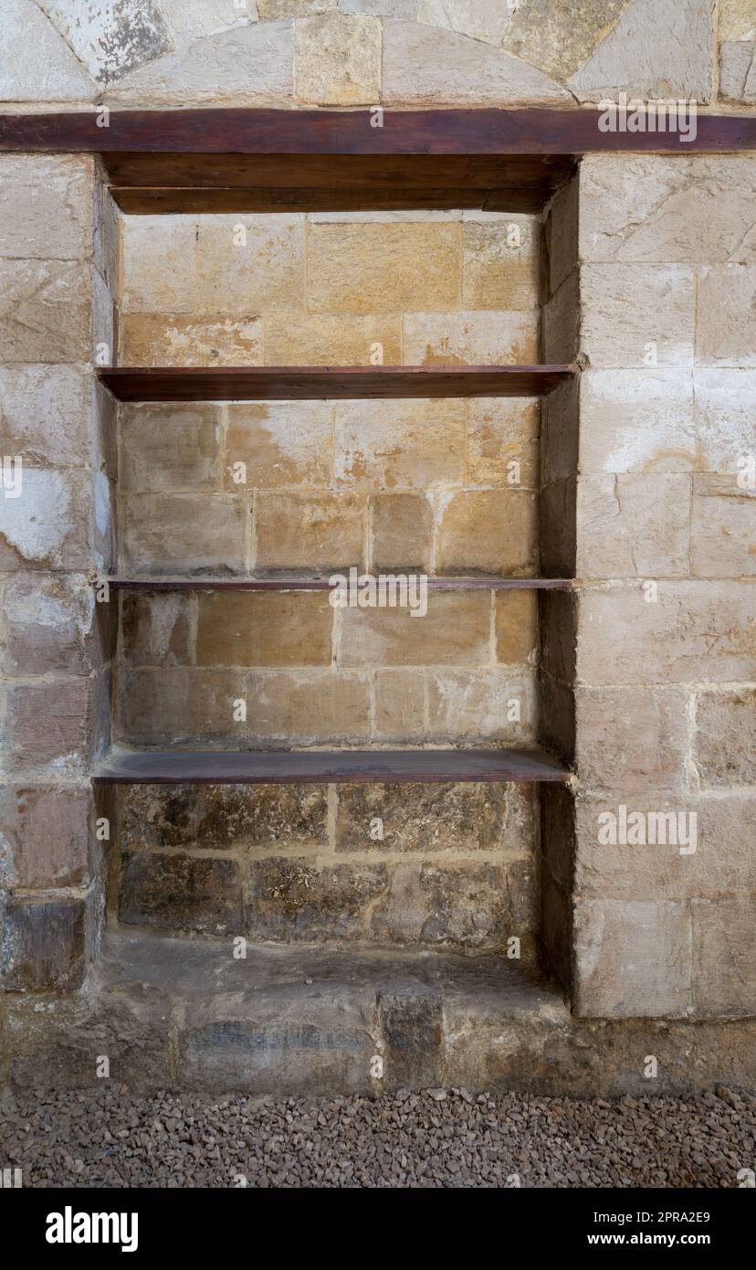 Recessed frame, Niche with wooden shelves in an old weathered stone