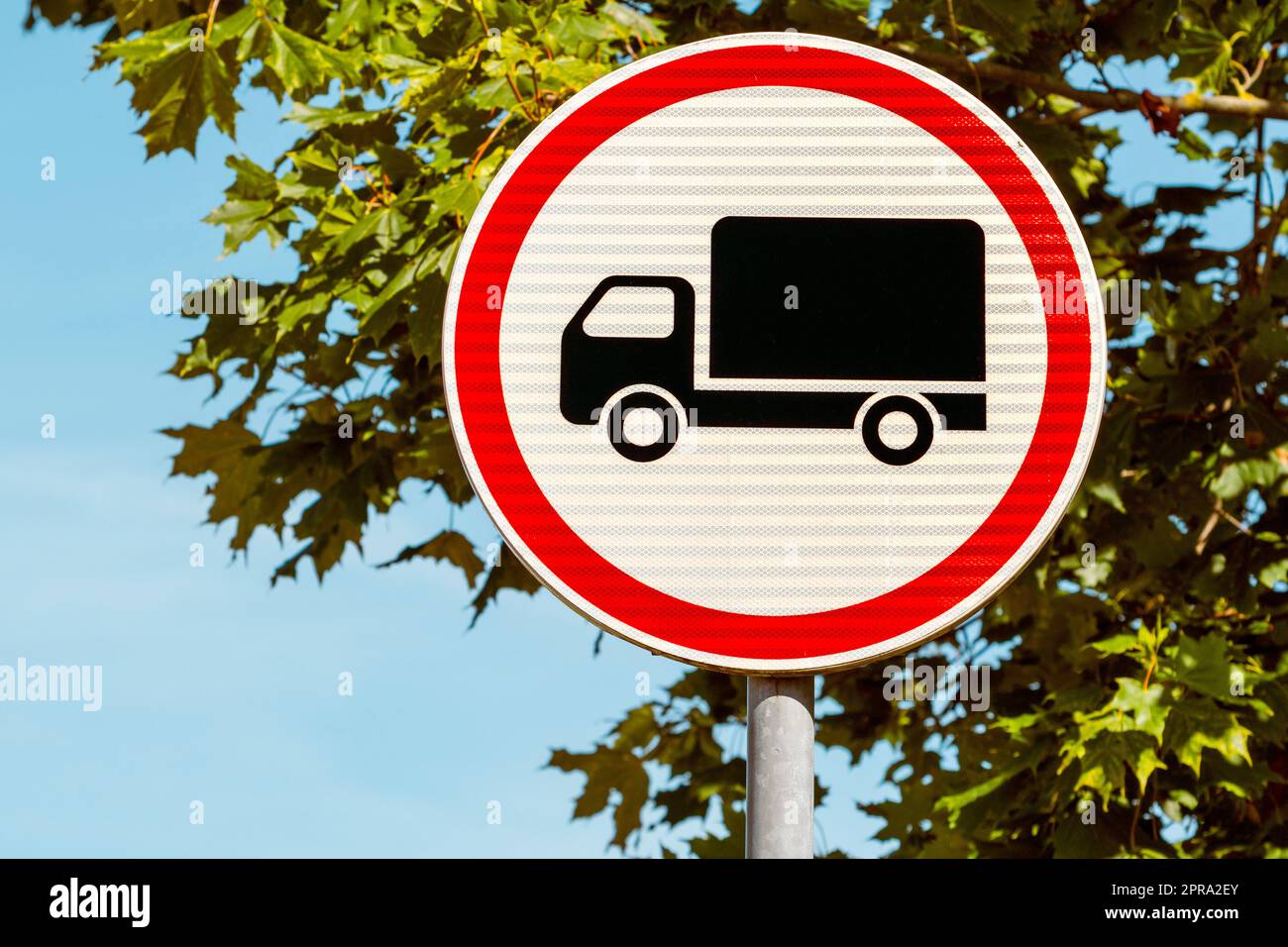Red and white round traffic sign with black cargo truck indicating No entry for trucks Stock Photo