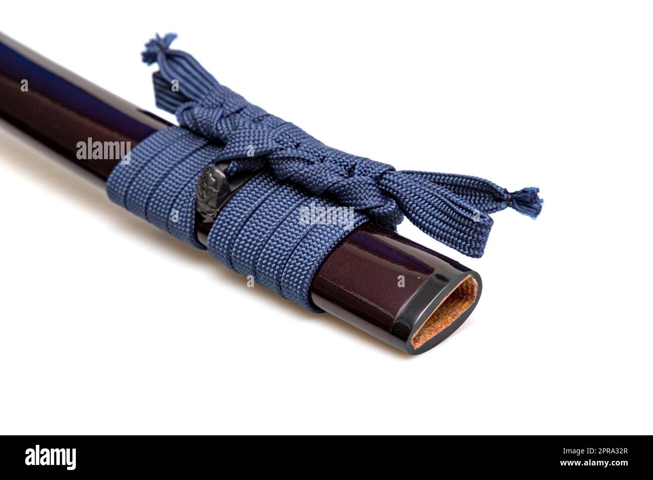 Navy Blue Sageo : Navy blue silk rope for tying.  Shining crimson Japanese scabbard isolated on a white background. Selective focus. Stock Photo