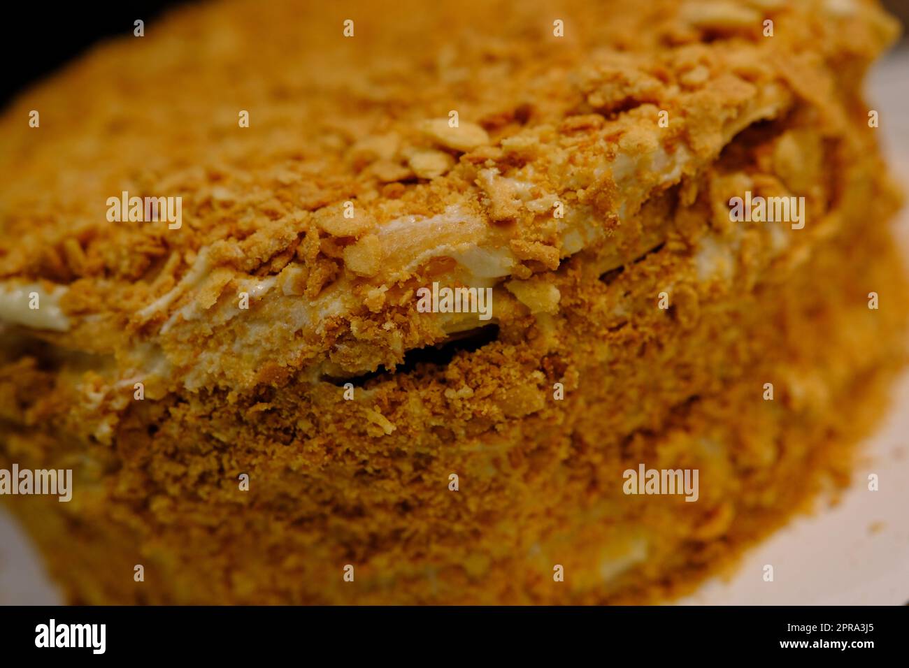 Board with delicious Napoleon cake, close up with selective blur Stock Photo