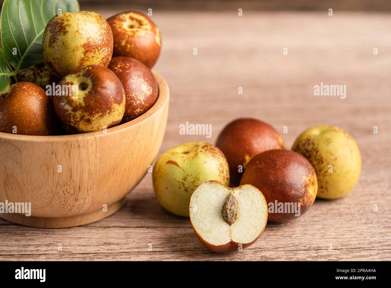 Jujube fruit or Chinese Dates in wooden bowl, healthy food Stock Photo