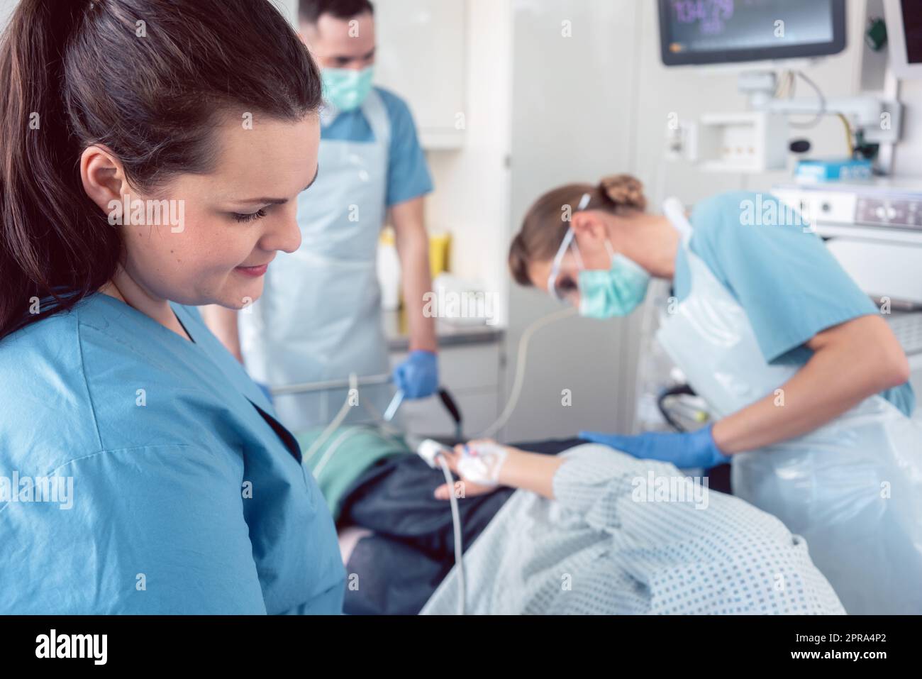 Team of doctors and nurses performing colonoscopy in hospital Stock
