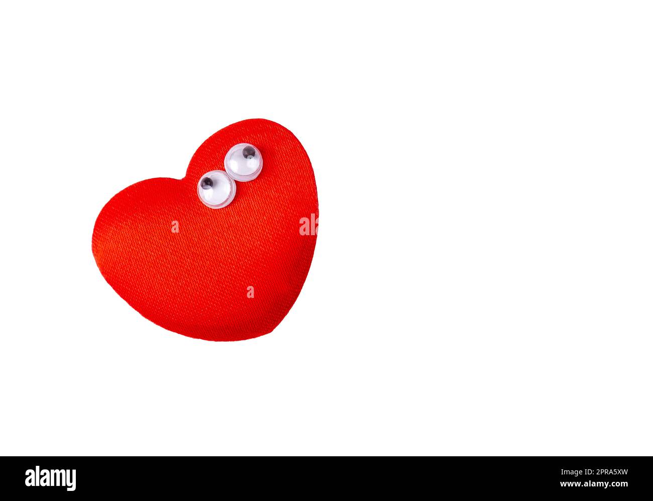 One single little funny quirky red heart with small googly eyes, object isolated on white background, cut out, nobody. Love symbol concept, single des Stock Photo