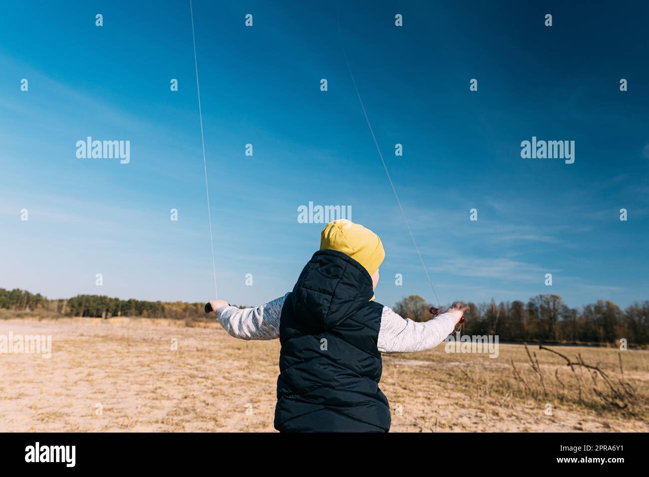 Caucasian Boy Of 6-7 Years Old Keep Two Twines From A Kites. Pleasant Activity In Fresh Air On A Sunny Spring Or Autumn Day Stock Photo